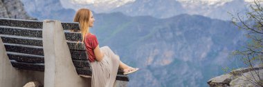 Banner, Karadağ 'daki Grlo Sokolovo boğazının nefes kesici panoramik manzarasının arka planında yer alan eski kadın turist. Ön planda bir dağ var. Düz tarafı bir uçurum oluşturuyor.