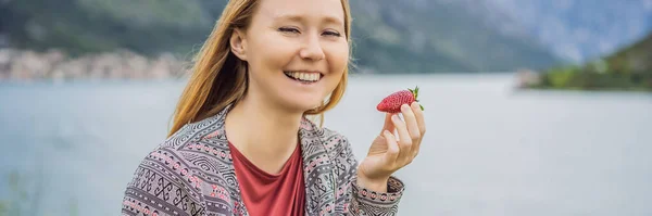 年轻迷人的女人在户外吃草莓Banner Long Format — 图库照片