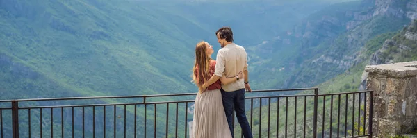 バナー ロングフォーマット遠くの山々に向かって緑の谷を流れる青い川を背景に幸せなカップルの観光客 モンテネグロとチエヴナ川の美しい山々 — ストック写真