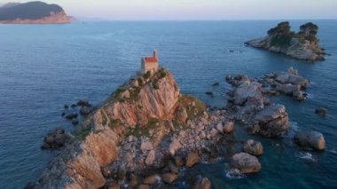 Hava videosu. Sveta Nedelja - Petrovac şehrine yakın küçük bir adadaki Hristiyan kilisesi Adanın üzerinde bir sürü kukla uçar.