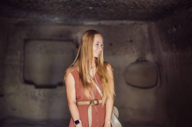 Kapadokya 'da Goreme yakınlarında kaya oluşumları ve peri mağaralarıyla vadiyi keşfeden genç bir kadın..