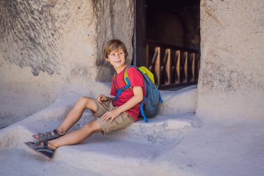 Kapadokya 'da Goreme yakınlarında kaya oluşumları ve peri mağaralarıyla vadiyi keşfeden çocuk turist..