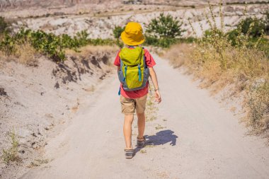 Kapadokya 'da Goreme yakınlarında kaya oluşumları ve peri mağaralarıyla vadiyi keşfeden çocuk turist..