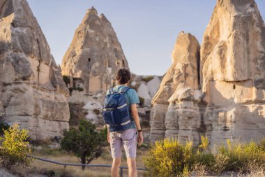 Kapadokya 'daki Aşk Vadisi' nde eşsiz jeolojik oluşumların arka planında erkek turist, Türkiye 'de popüler seyahat merkezi.