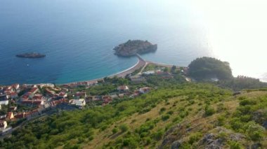 Budva kenti yakınlarındaki Sveti Stefan adasının üzerindeki Saint Sava kilisesini iki kadın ziyaret ediyor. Karadağ 'a seyahat. Yavaş çekim videosu.