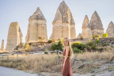Kapadokya 'daki Aşk Vadisi' nde eşsiz jeolojik oluşumların arka planında yer alan kadın turist, Türkiye 'de popüler seyahat beldesi.