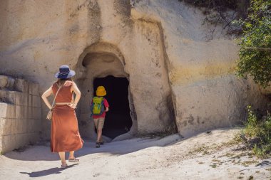 Anne ve oğul turistler Kapadokya 'da Goreme yakınlarında kaya oluşumları ve peri mağaralarıyla vadiyi keşfediyorlar..