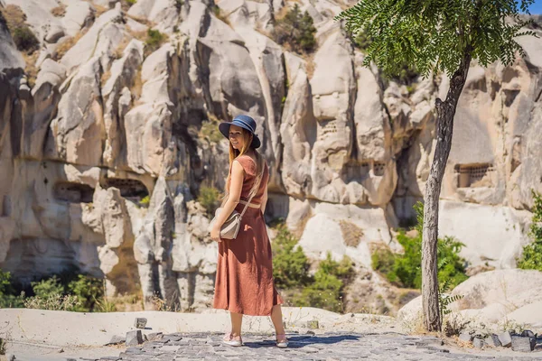 stock image Young woman exploring valley with rock formations and fairy caves near Goreme in Cappadocia Turkey.