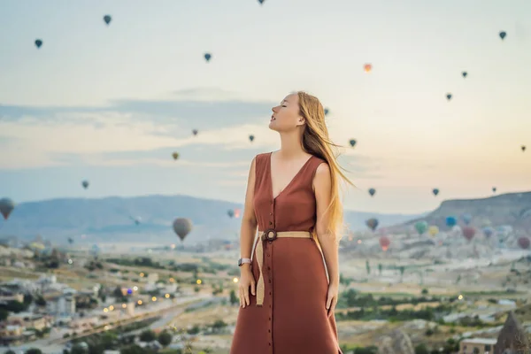 stock image Tourist woman looking at hot air balloons in Cappadocia, Turkey. Happy Travel in Turkey concept. Woman on a mountain top enjoying wonderful view.