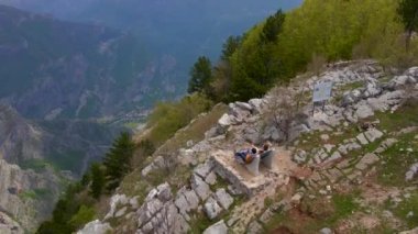 Grlo Sokolovo Kanyonu 'nu ziyaret eden bir turist ailesinin klibi Karadağ' da ünlü bir turistik yer. Kanyon manzaralı bir bankta oturuyorlar..