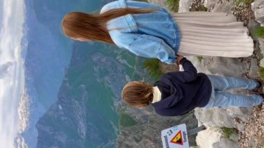 Dikey video. Genç bir kadın ve oğlu turistler Grlo Sokolovo Kanyonu 'nu ziyaret ediyorlar. Karadağ 'da nefes kesici bir manzara.