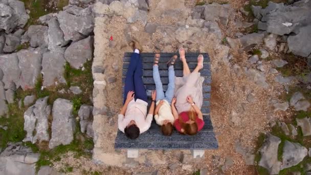 モンテネグロの有名な観光地であるグロソコロボ渓谷を訪れる観光客の家族の空中ビデオ 彼らは峡谷の息をのむような景色を望むベンチに座っています — ストック動画
