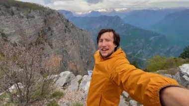 Karadağ-Arnavutluk sınırındaki ünlü bir kanyon olan Grlo Sokolovo 'yu ziyaret eden genç bir adam görülüyor. Telefondan selfie videosu kaydediyor. Karadağ 'a Seyahat.