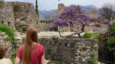 Slowmotion video. A young woman and her son visit the ruins of the Bar old city or Stari Grad. A destroyed ancient settlement close to the city of Bar. Travel destinations of Montenegro.