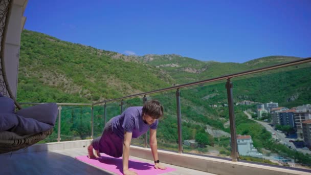 小伙子们正在一个以海山为背景的现代化的公寓里练瑜伽 — 图库视频影像