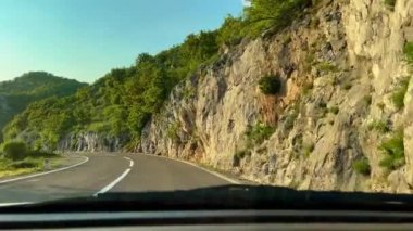 Road trip on a car through mountains during sunset.