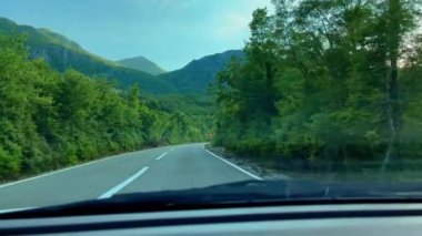 Road trip on a car through mountains during sunset.