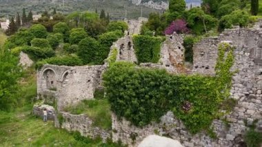 Slowmotion video. A young woman visits the ruins of the Bar old city or Stari Grad. A destroyed ancient settlement close to the city of Bar. Travel destinations of Montenegro.