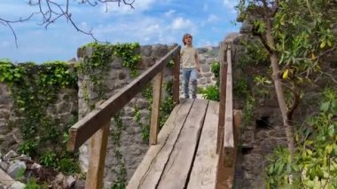 Slowmotion video. A young woman and her son visit the ruins of the Bar old city or Stari Grad. A destroyed ancient settlement close to the city of Bar. Travel destinations of Montenegro.