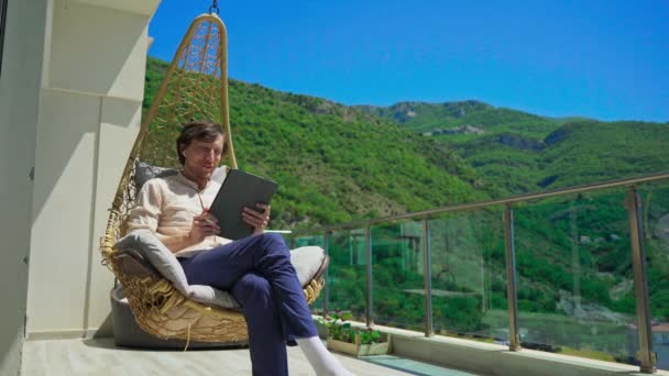 Young Man Balcony Surrounded Stunning Mountain Scenery Siting Comfortable Swinging — Stockvideo