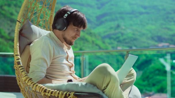 Young Man Balcony Surrounded Stunning Mountain Scenery Comfortable Swinging Chair — Stockvideo