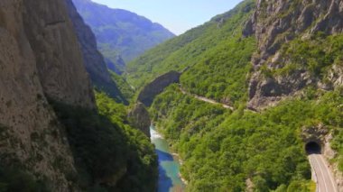 Aerial video of the stunning Moracha River canyon in Montenegro. Soar above the magnificent natural scenery, capturing stunning aerial views of the towering cliffs, crystal-clear river, and lush