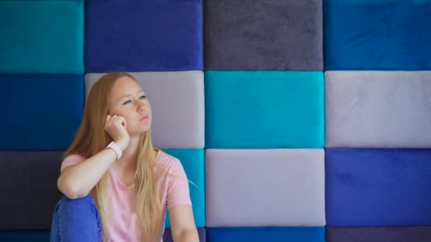 Young Woman Sits Amidst Interesting Background Gray Blue Rectangles Surrounded — Vídeo de stock