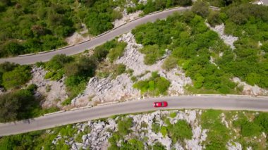This stock video showcases the stunning aerial views of the Kotor-Cetinje serpentine in Montenegro. The winding road that leads through the rugged mountain scenery is truly a sight to behold. Captured