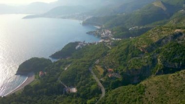 Aerial video. Drone flies along the shoreline of Montenegro close to the city of Budva and Sveti Stefan island.