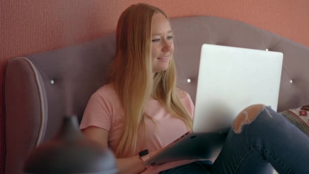 Eine Junge Frau Sitzt Gemütlich Auf Einem Bett Und Arbeitet — Stockvideo