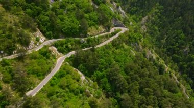 This stock video showcases the stunning aerial views of the Kotor-Cetinje serpentine in Montenegro. The winding road that leads through the rugged mountain scenery is truly a sight to behold. Captured
