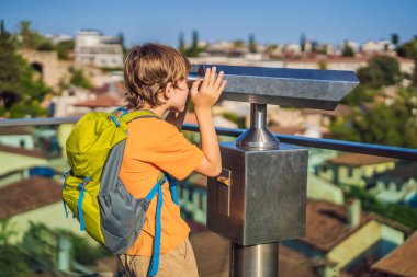 Erkek turist Antalya 'nın Eski Kaleici kasabasındaki dürbünlerden bakıyor. Hindi. Antalya Eski Kent limanı, Taurus dağları ve Akdeniz 'in panoramik manzarası, Türkiye. Çocuk konseptiyle seyahat etmek.