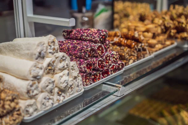 Traditional oriental sweet pastry cookies, nuts, dried fruits, pastilles, marmalade, Turkish desert with sugar, honey and pistachio, in display at a street food market.