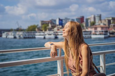 İstanbul 'da İstanbul Boğazı' ndan geçen feribottan denizin keyfini çıkaran mutlu kadın. İstanbul 'a yaz gezisi.