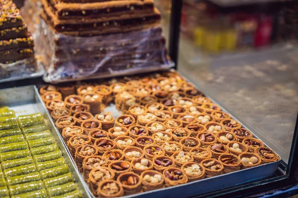Traditional oriental sweet pastry cookies, nuts, dried fruits, pastilles, marmalade, Turkish desert with sugar, honey and pistachio, in display at a street food market.
