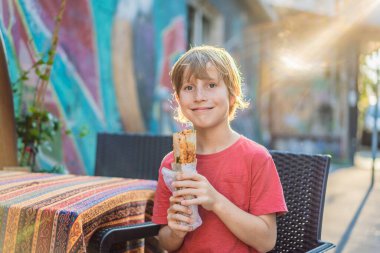 İstanbul 'da sokak yemeği yiyen bir çocuk. Balik ekmek - ekmek arası balık, geleneksel Türk fast food 'u. İstanbul, Türkiye.
