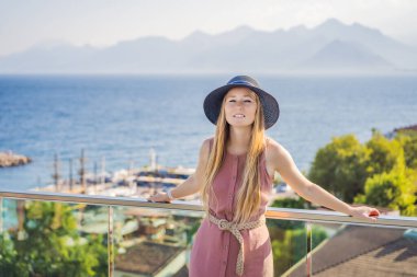 Antalya 'nın Kaleici kasabasındaki kadın turist. Hindi. Antalya Eski Kent limanı, Taurus dağları ve Akdeniz 'in panoramik manzarası, Türkiye.