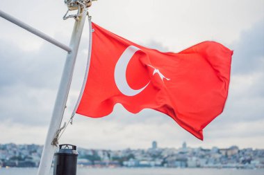 Türk bayrağı rüzgârda dalgalanırken denizin arka planında ve sahilde.