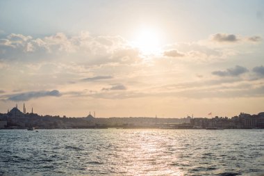 Günbatımında İstanbul, Türkiye. Turist teknesi yazın Golden Horn 'dan denize açılır. İstanbul 'un eski camili güzel güneşli manzarası. İstanbul ve Türkiye 'de seyahat, turizm ve tatil kavramı