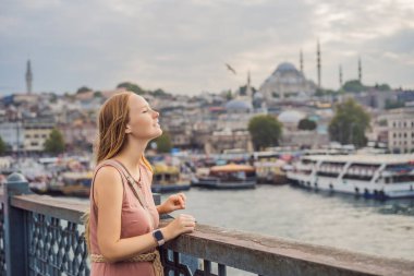 Galata Köprüsü, Golden Horn Körfezi, İstanbul 'da genç bir turist kadın. Meşhur turizm merkezi Boğaz Kanalı 'nın Panorama şehri. Seyahat manzarası Boğaz, Türkiye, Avrupa ve Asya.