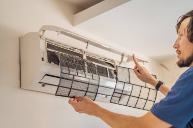 temizlik için klimanın hava filtresini kaldıran teknisyen servisi.