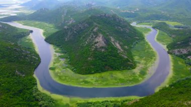 Karadağ 'daki Skadar Gölü yakınlarındaki Pavlova Strana' daki at nalı şeklindeki nehir kıvrımının çarpıcı görüntülerini kaydediyor. Görüntüler doğal güzelliğin büyüleyici bir görüntüsünü sağlıyor.