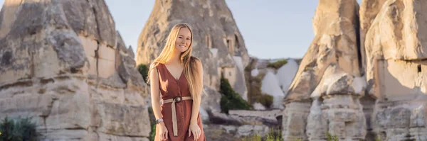 stock image BANNER, LONG FORMAT Woman tourist on background of Unique geological formations in Love Valley in Cappadocia, popular travel destination in Turkey.