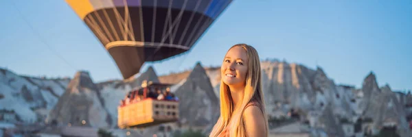 バナー トルコのカッパドキアで熱気球を見てロングフォーマット観光の女性 トルコのコンセプトでハッピートラベル 山頂の女が素晴らしい景色を楽しむ — ストック写真