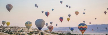 Kapadokya üzerinde uçan renkli sıcak hava balonu, Türkiye. BANNER, BÜYÜK