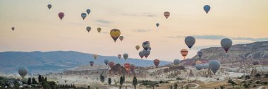 Kapadokya üzerinde uçan renkli sıcak hava balonu, Türkiye. BANNER, BÜYÜK