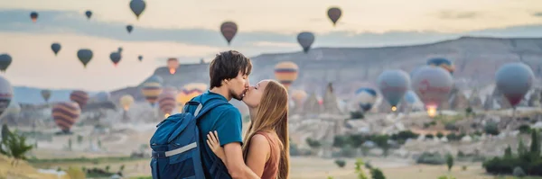 バナー ロングフォーマット観光客カッパドキア トルコの熱気球を見てカップルの男性と女性 トルコのコンセプトでハッピートラベル 山の上のカップルの男と女が素晴らしい景色を楽しむ — ストック写真