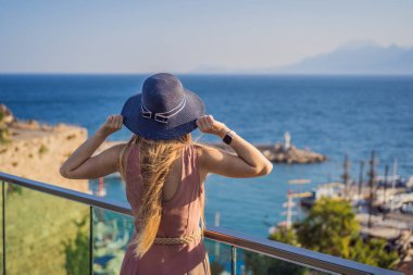 Antalya 'nın Kaleici kasabasındaki kadın turist. Hindi. Antalya Eski Kent limanı, Taurus dağları ve Akdeniz 'in panoramik manzarası, Türkiye.