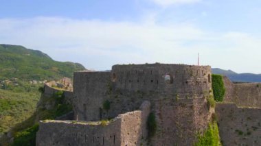 This aerial stock video captures the stunning ruins of the Old Bar or Stari Bar, a historical landmark in Montenegro. The drone footage showcases a birds eye view of a stone fortress and an aqueduct