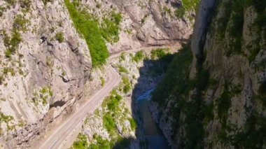 Aerial video of the stunning Moracha River canyon in Montenegro. Soar above the magnificent natural scenery, capturing stunning aerial views of the towering cliffs, crystal-clear river, and lush